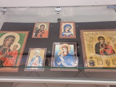 Sześć wizerunków ikona sakralnych przedstawiających Matkę Boską z Dzieciątkiem oraz postaci religijne, eksponowanych w płaskiej szklanej gablocie